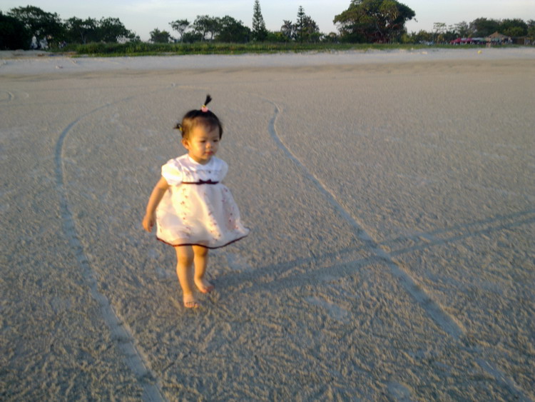 五月初的银滩上走来一个娇俏的小姑娘,光着小脚丫走在满是小螃蟹钻来