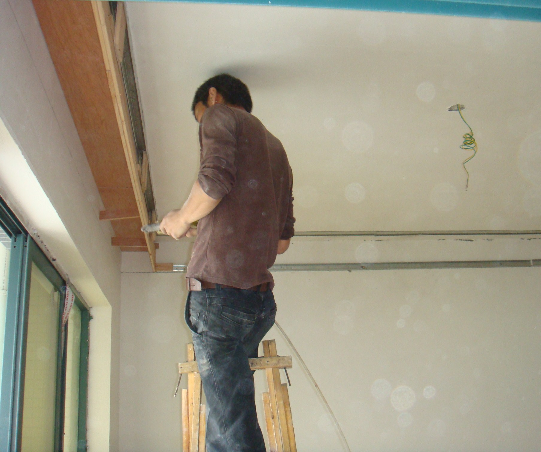 木工在做窗帘盒部位的吊顶.