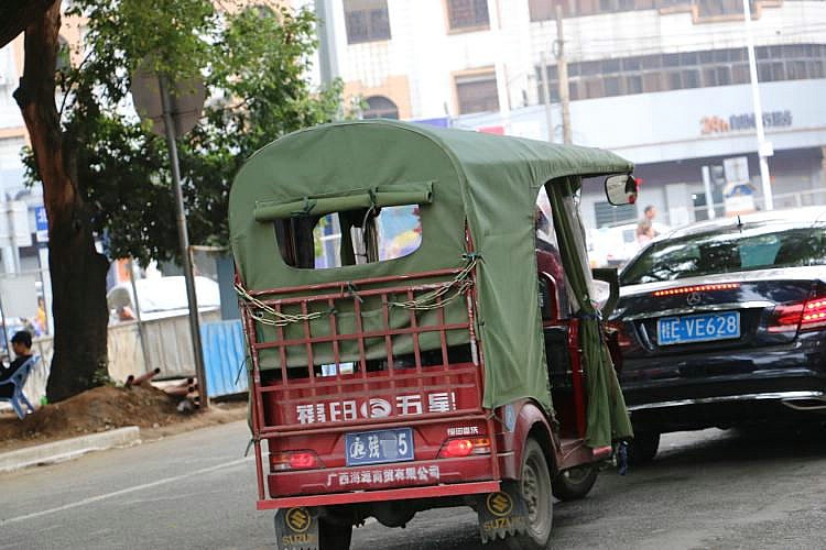 那知,一些不和谐的镜头闯入了镜头,残疾人的三轮电动车,在抢着节日的