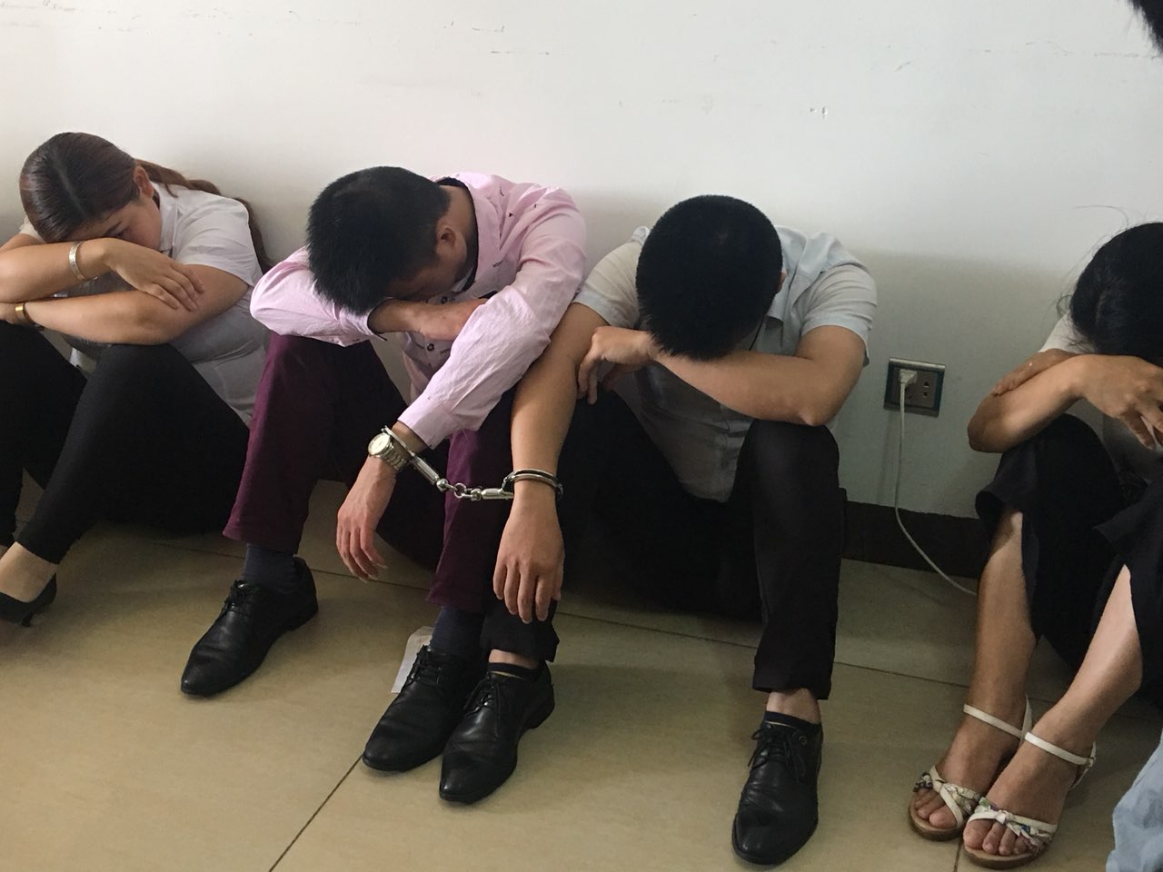 两个人一副手铐,全部拷好,准备带走.