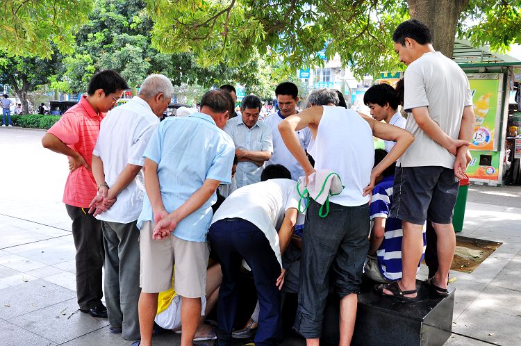 广场里有一群人围拢在一起,不知他们干什么?