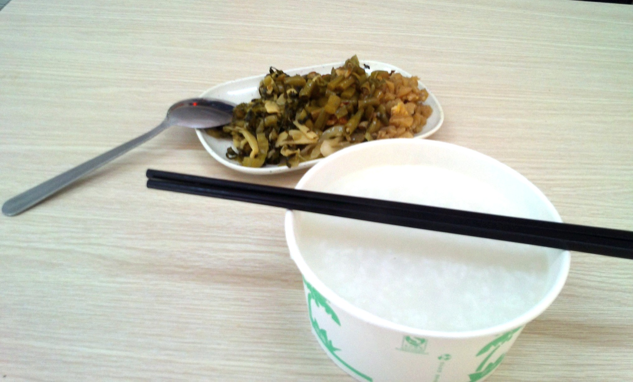 早餐内容为:一碗稀饭,一碟小菜,小菜包括榨菜,酸豆角,萝卜干和咸菜