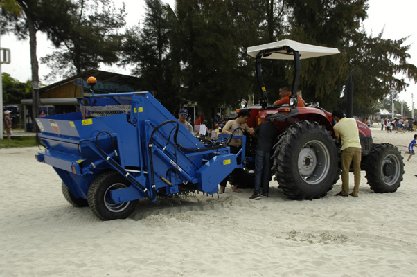 拖着一辆进口法国"moreau"沙滩清洁机在沙滩进行来回清扫沙滩上的垃圾